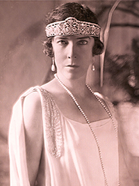 Koningin Elisabeth in witte avondjurk met de tiara laag op haar hoofd