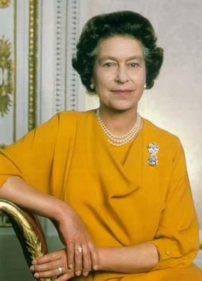 Koningin Elizabeth poseert glimlachend in een oranje jurk terwijl ze zit op een stoel.